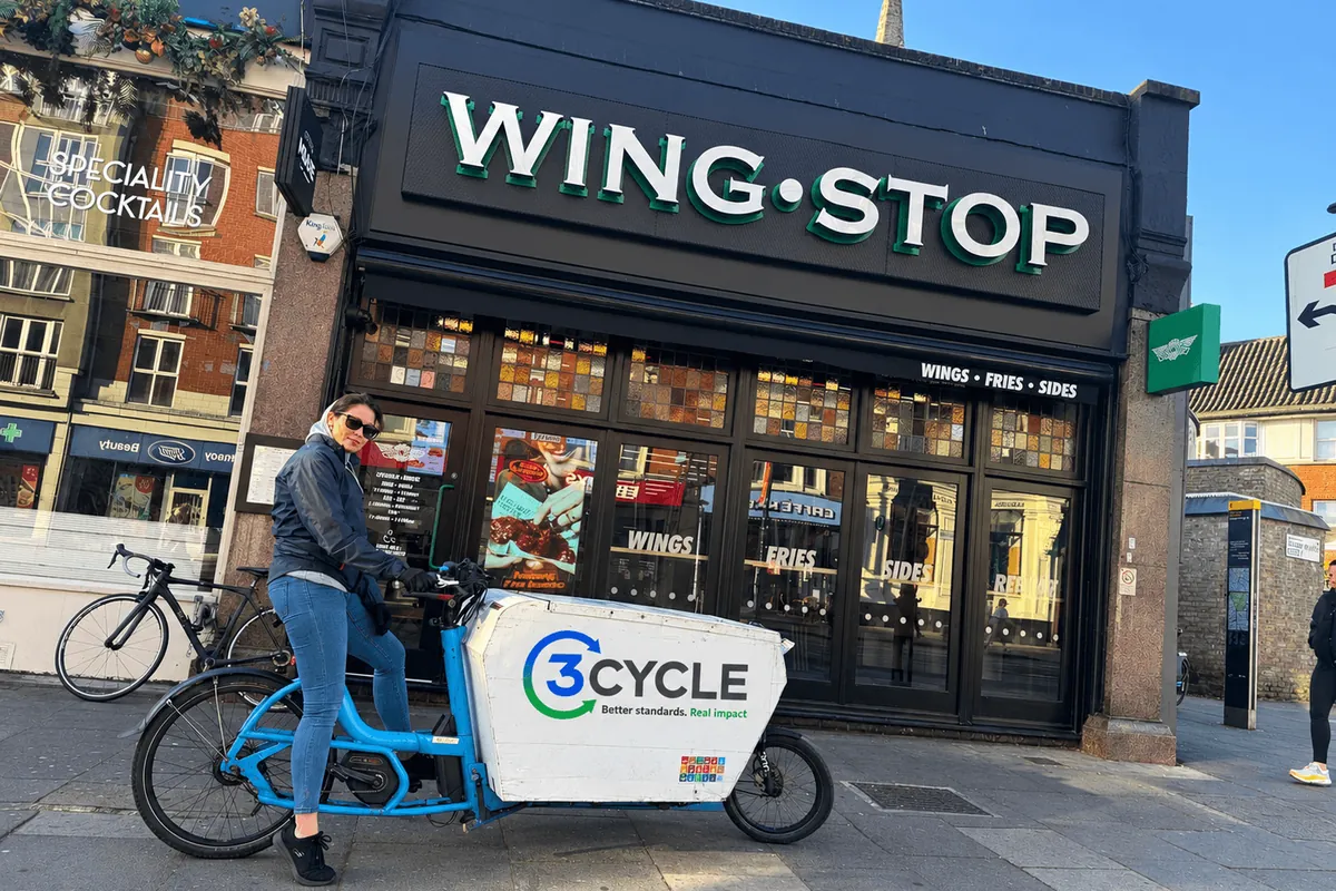 3Cycle rider on a cargo bike outside a Wingstop restaurant in London